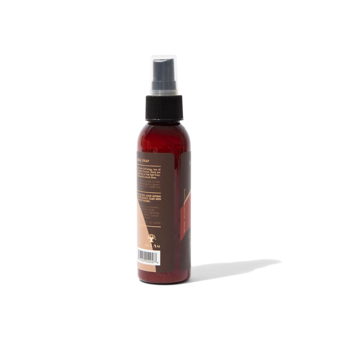 Bagside af en brun sprayflaske med en hvid etiket. Flasken indeholder As I Am Classic CocoShea Spray. Etiketten viser produktinformationer som ingredienser, anvendelsesvejledning og advarsler.