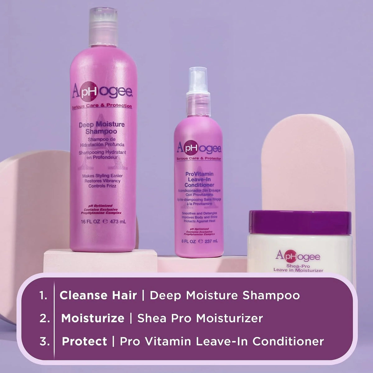 ApHogee Deep Moisture Shampoo, ProVitamin Leave-In Conditioner og Shea-Pro Moisturizer i lyserøde og hvide flasker på lilla baggrund.