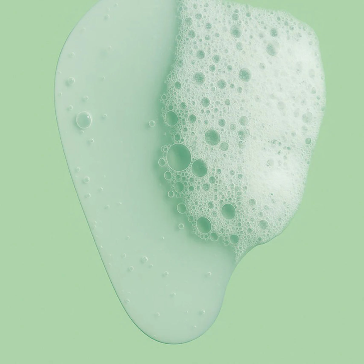 Nettoyant visage légèrement moussant sous forme liquide de consistance douce sur fond vert clair.