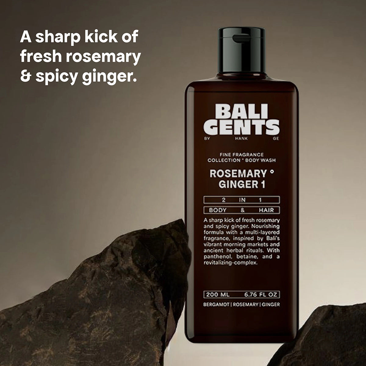 Bali Gents Shower Gel Rosemary Ginger 1 200ml in brown bottle stands between dark stones on a beige background.