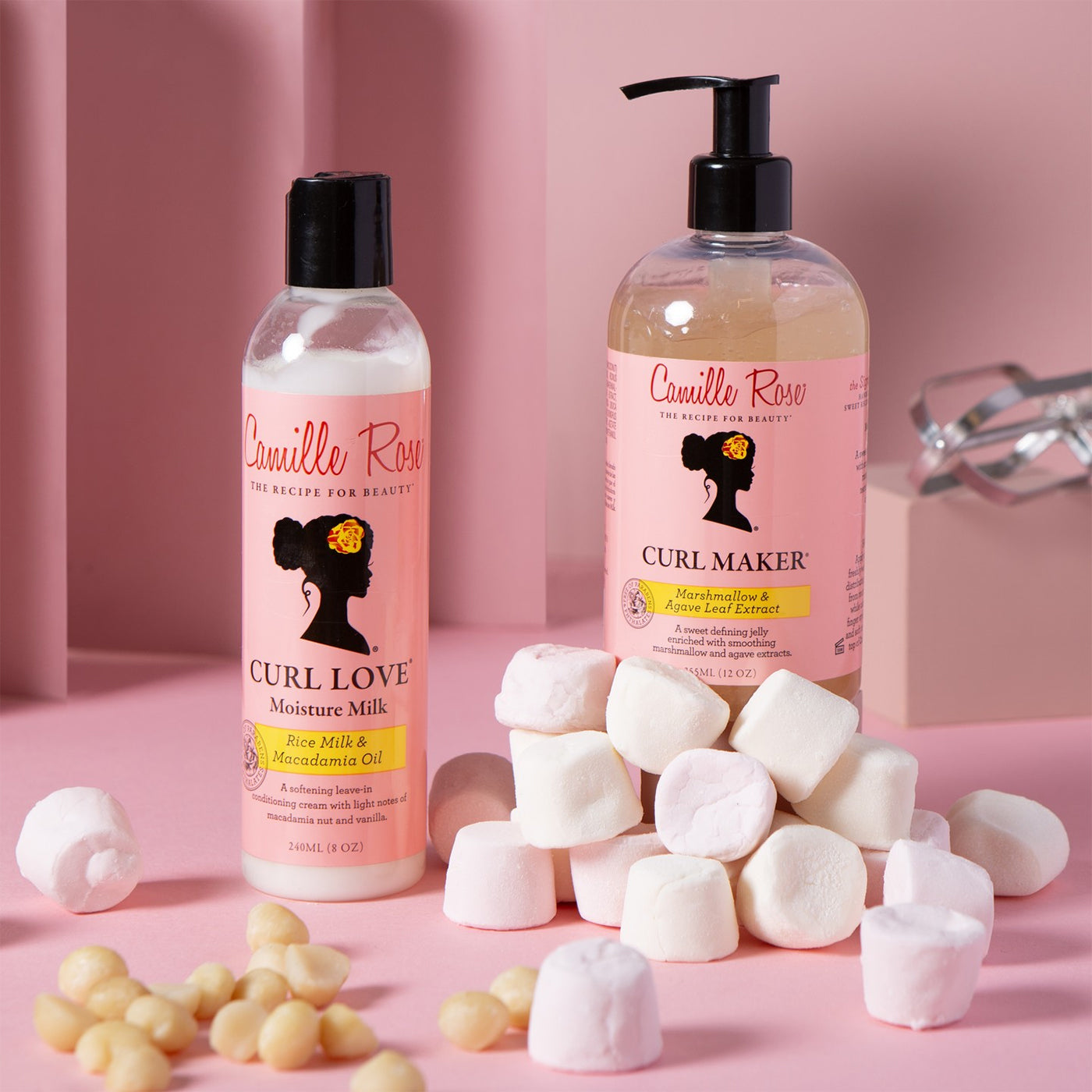 Camille Rose Curl Love Moisture Milk og Curl Maker i hvide/lyserøde flasker med macadamianødder og skumfiduser.
