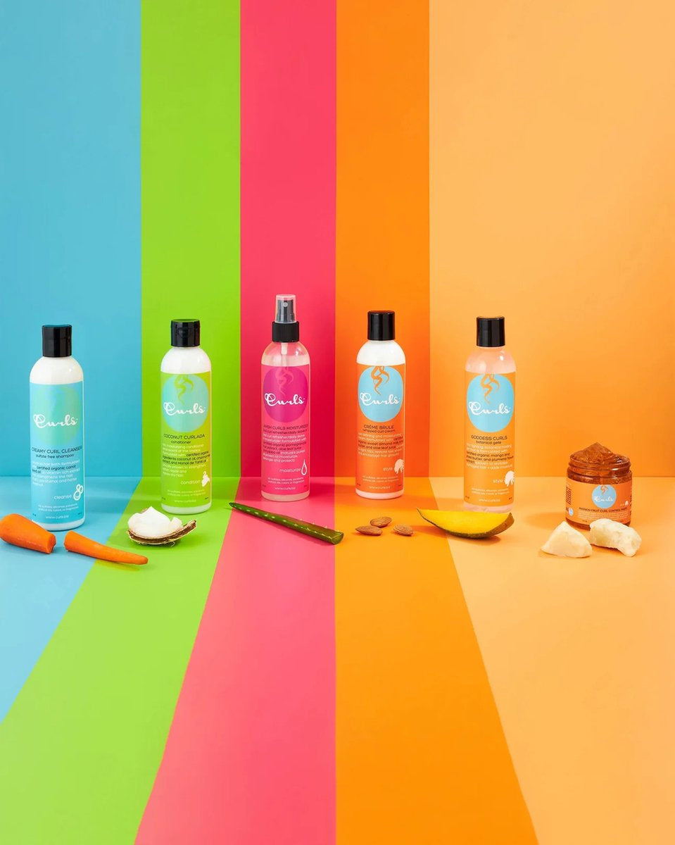 Produktserie fra Curls med farverige baggrunde og naturlige ingredienser. Inkluderer Curls Coconut Curlada Conditioner (hvid flaske med grøn etiket), og andre produkter med hvide flasker og etiketter i forskellige farver (lyserød, orange, lyseblå). 