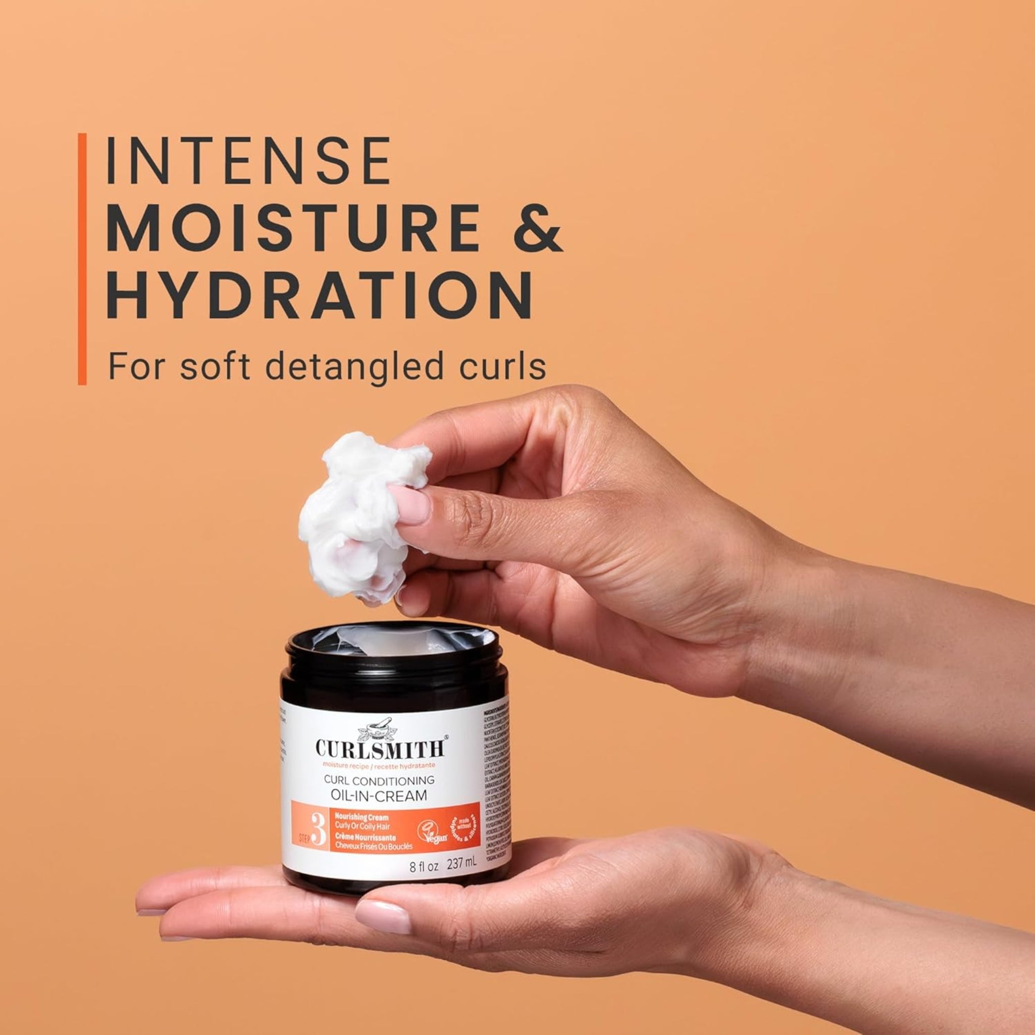 Curlsmith Curl Conditioning Oil-In-Cream creme i sort krukke, hånd tager cremet produkt til intens hydration af krøller.