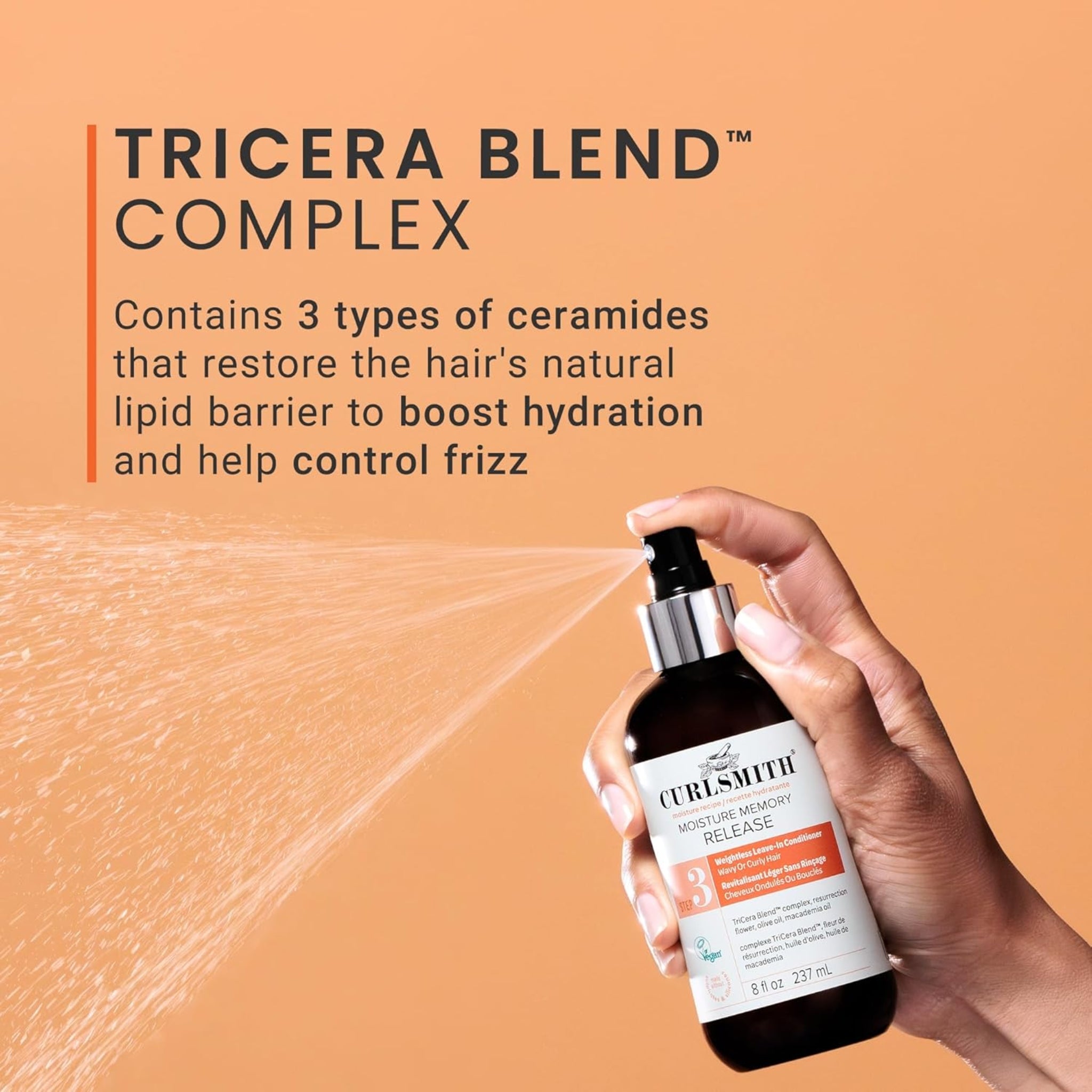 Hånd sprayer Curlsmith Moisture Memory Release med TriCera Blend Complex på orange baggrund.