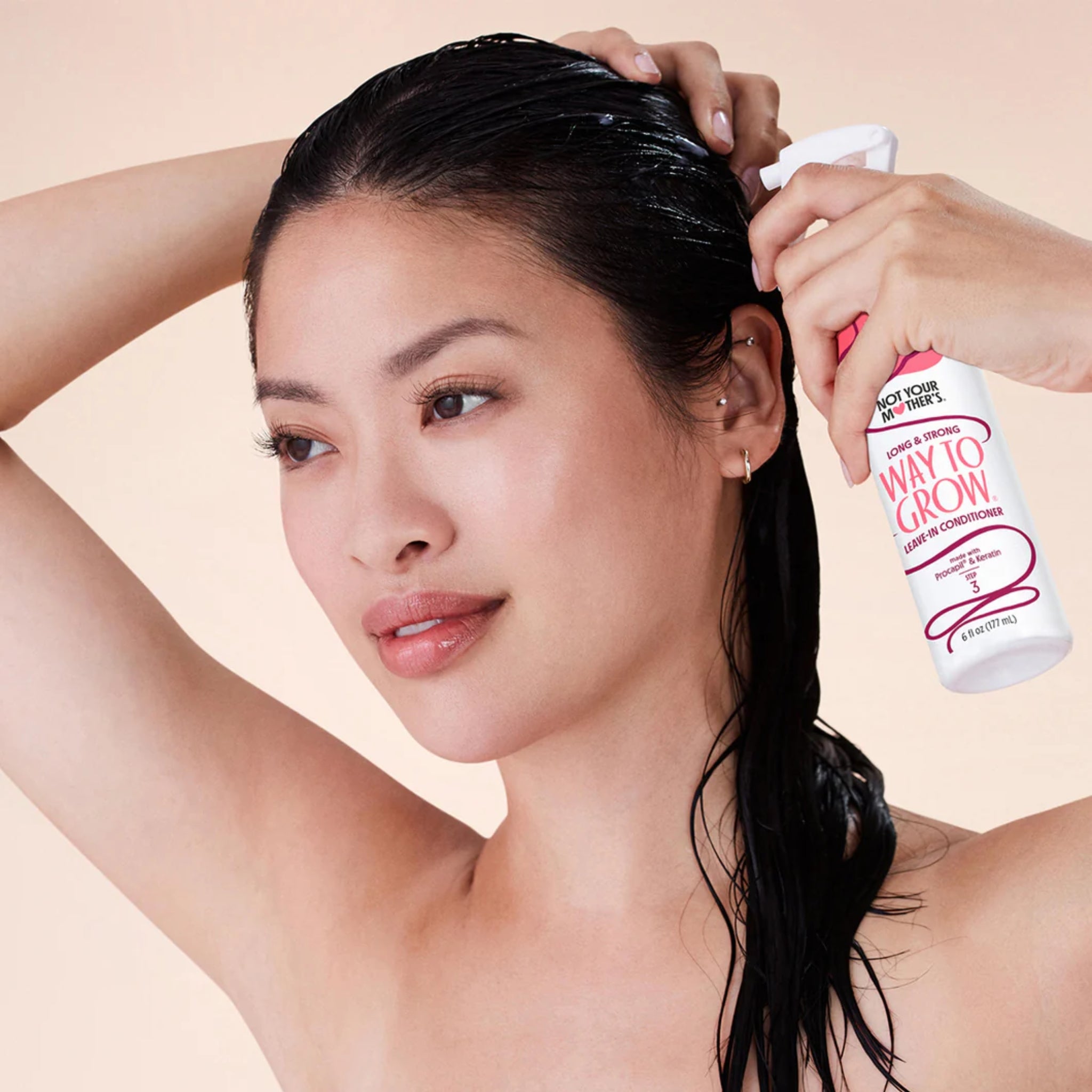 Kvinde med vådt hår sprayer Not Your Mother's Way To Grow leave-in conditioner i håret.