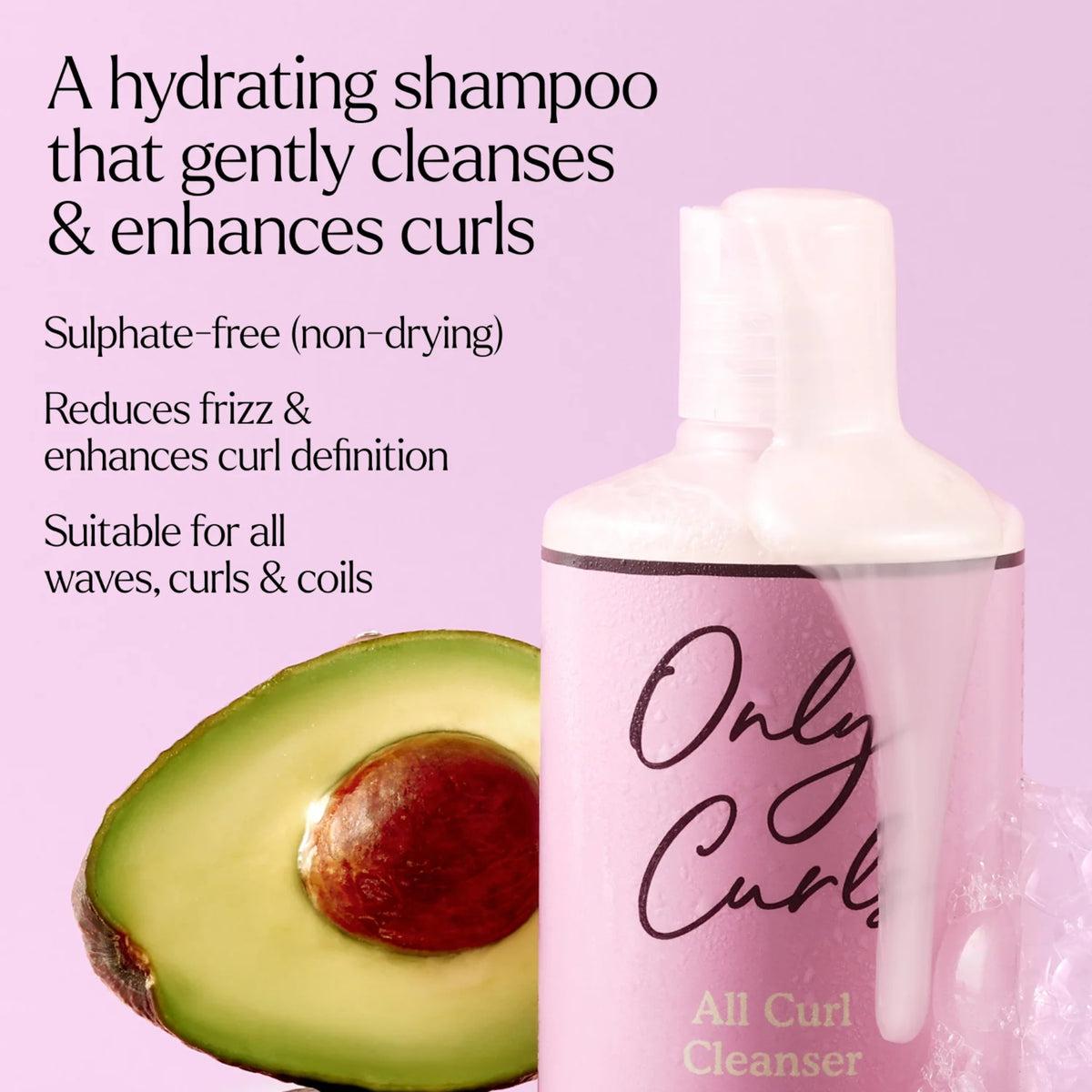 Only Curls All Curl Cleanser hydrating shampoo-flaske i pink ved siden af halveret avocado.