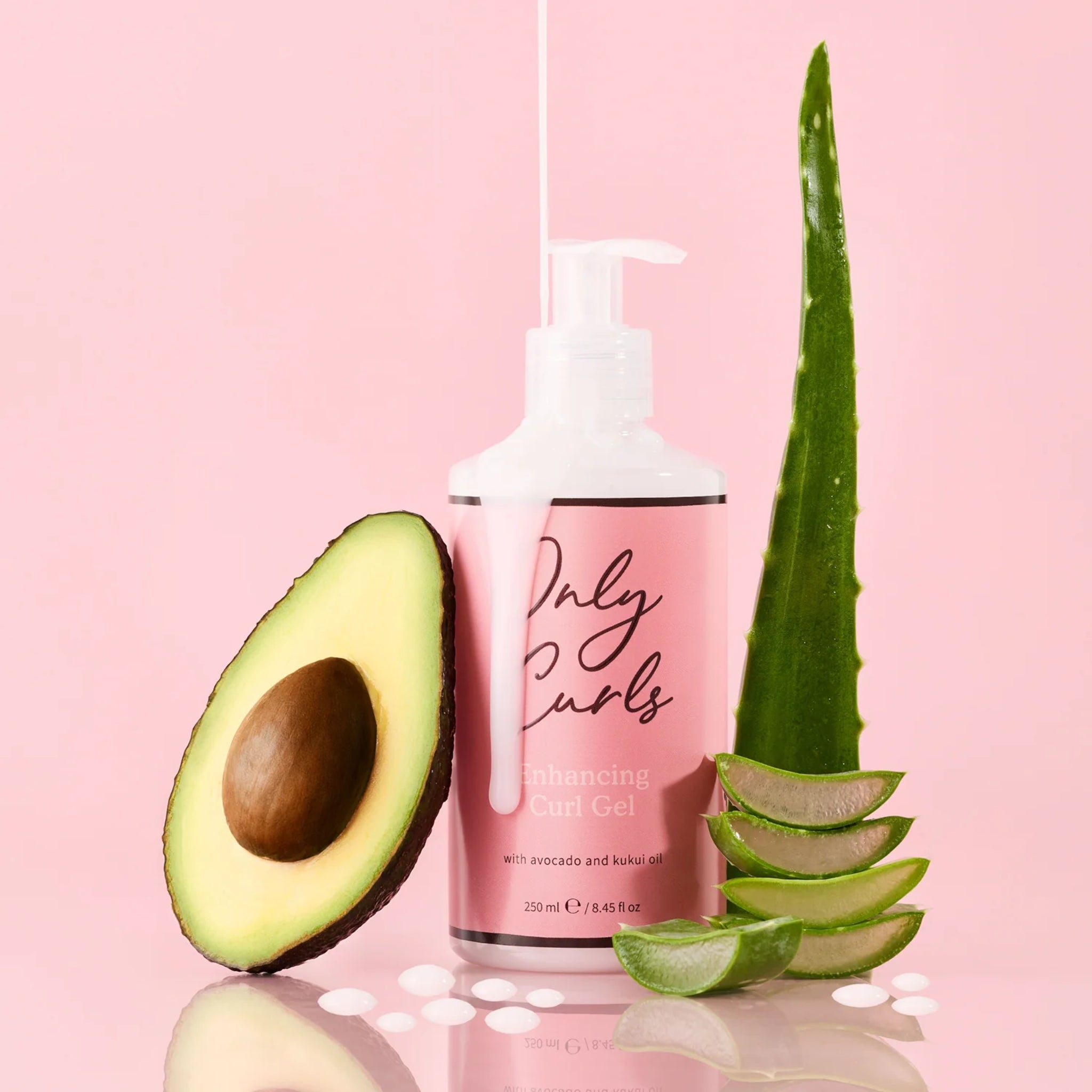 Only Curls Enhancing Curl Gel-pumpeflaske med avocado og aloe vera på lyserød baggrund.
