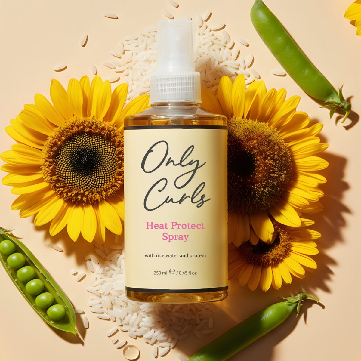 Only Curls Heat Protect Spray-flaske mellem solsikker, ris og ærtebælge på cremet baggrund.