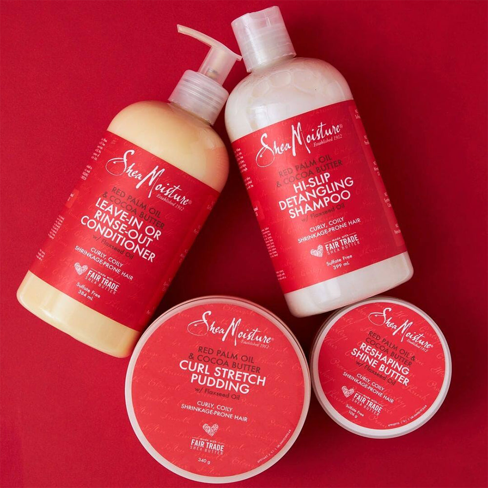 Shea Moisture Red Palm Oil & Cocoa Butter produktserie. Billedet viser fire produkter: Hi-Slip Detangling Shampoo, Leave-In or Rinse-Out Conditioner, Curl Stretch Pudding og Reshaping Shine Butter, alle beregnet til krøllet og krympet hår.